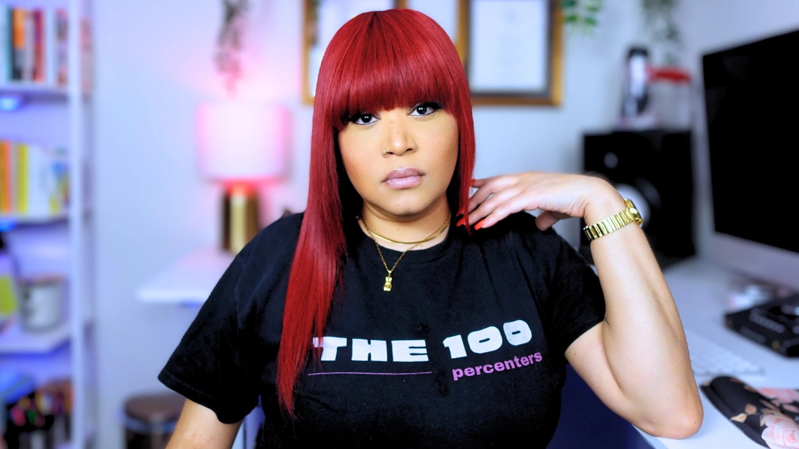 Tiffany Red at her desk wearing a The 100 Percenters T-shirt